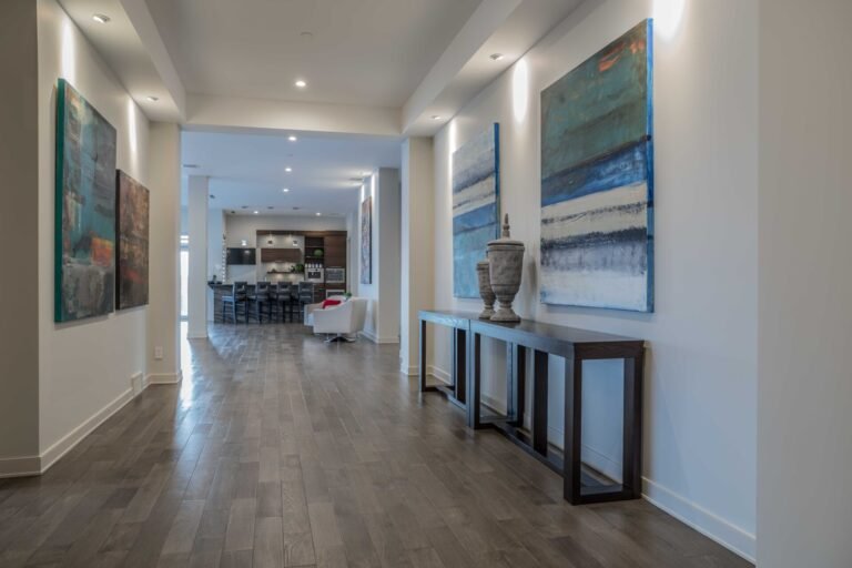 Modern open concept living and kitchen area with large abstract paintings and contemporary furniture